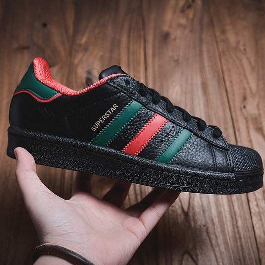 black adidas with green stripes